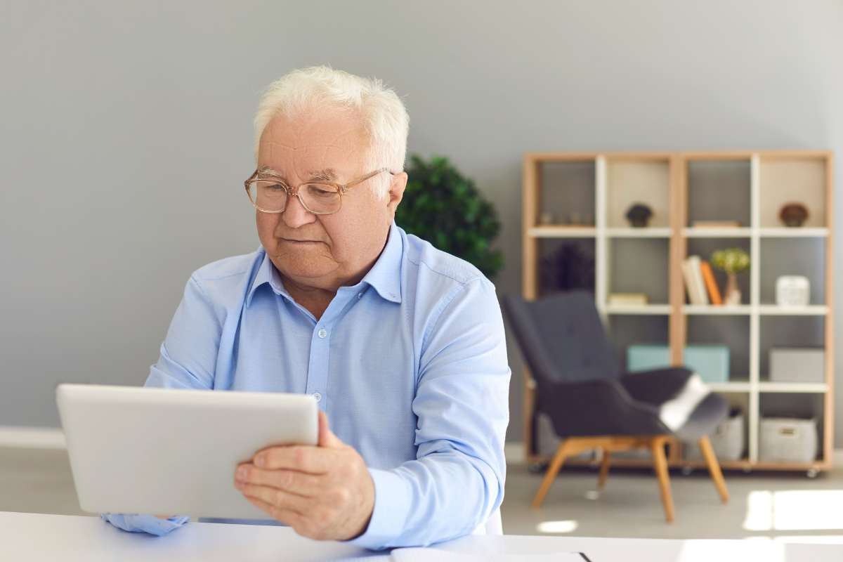Signore anziano guarda il tablet