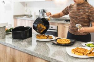 Donna che cucina con friggitrice ad aria
