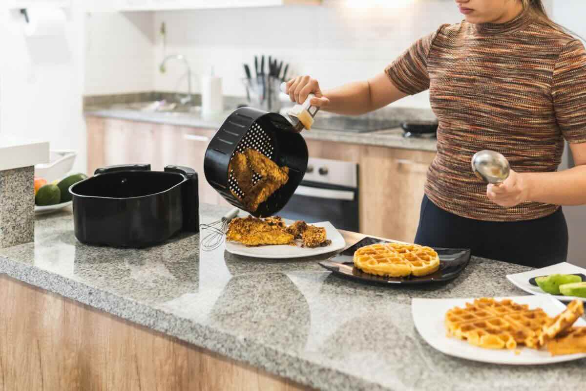 Donna che cucina con friggitrice ad aria 