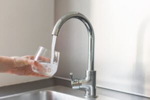 Acqua che esce dal rubinetto e bicchiere