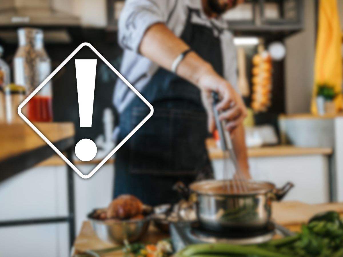 uomo che cucina e segnale pericolo