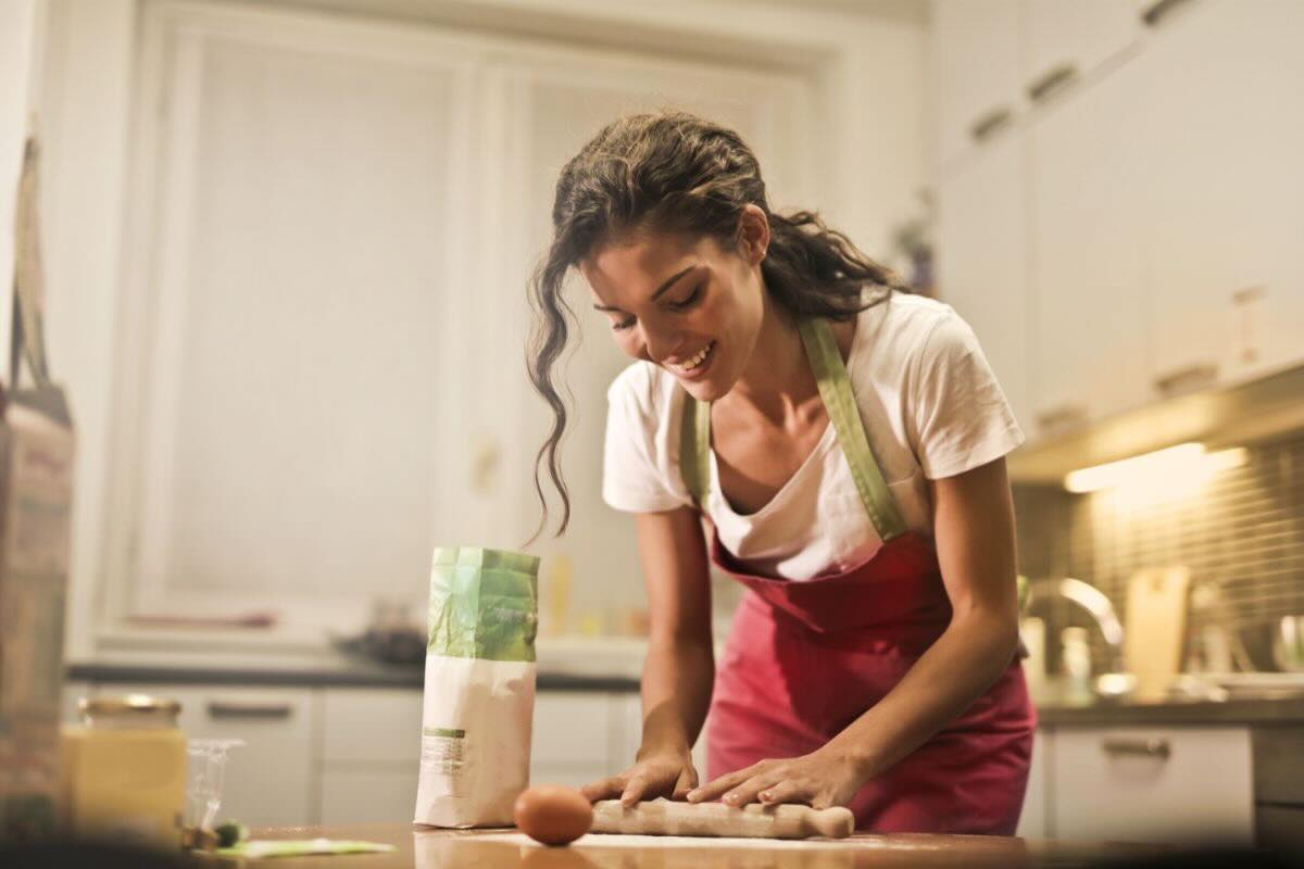 Donna stende la pasta fatta in casa