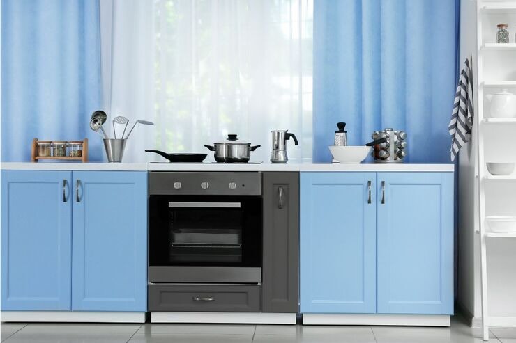 Cucina azzurra con tende sul retro bianche e azzurre