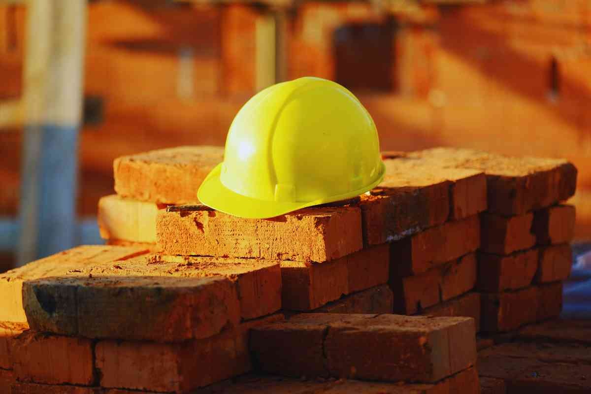 casco da operaio sopra a mattoni