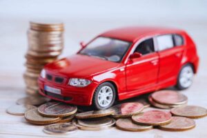 Modellino auto accanto a pila di monete