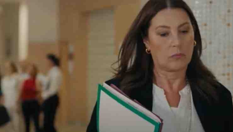 donna che cammina con cartellina sotto braccio