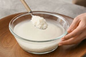 Mestolo con riso, acqua in ciotola