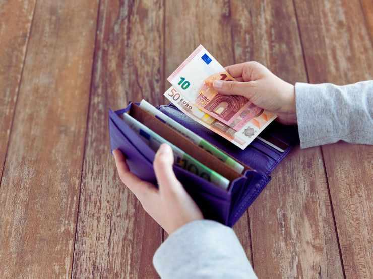 portafoglio con mano che prende soldi 