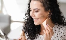 Donna applica fondotinta con spugnetta