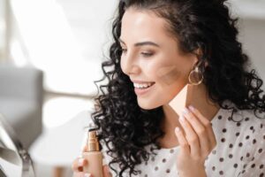 Donna applica fondotinta con spugnetta